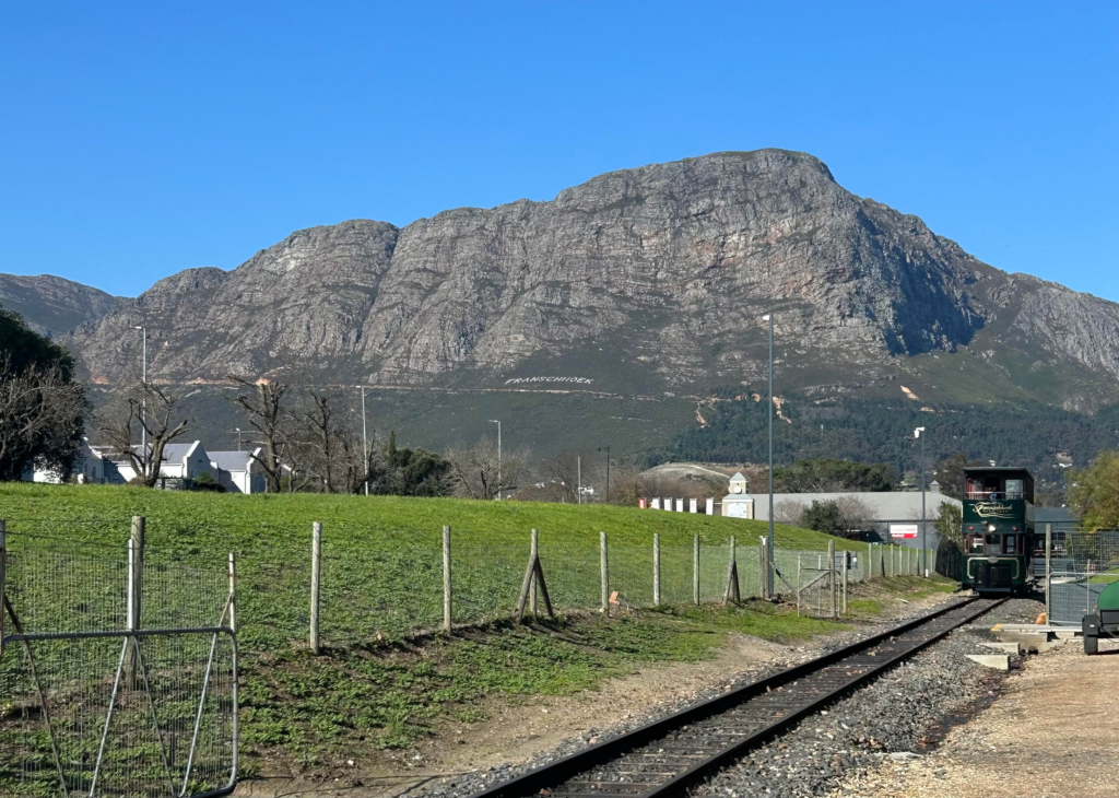 Wine tram in Franschhoek against a mountain backdrop in the Cape Winelands