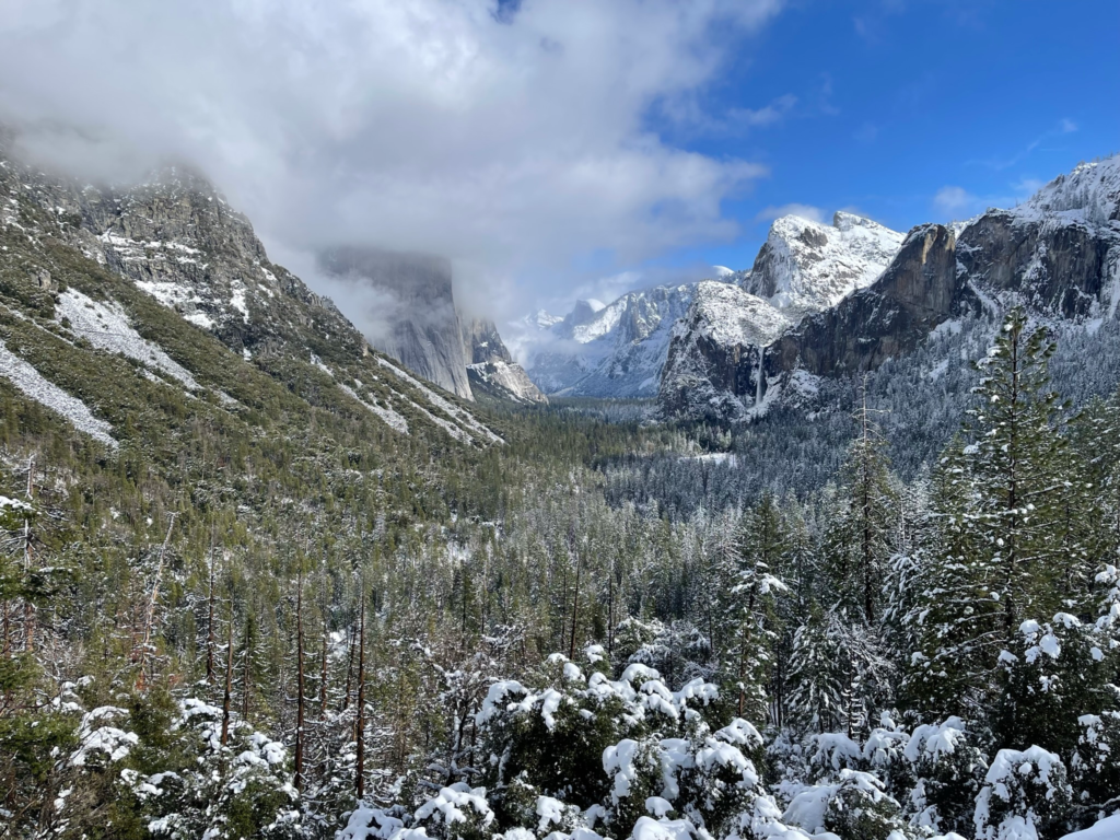 Tunnel View covered in snow and partially obscured by clouds on a Yosemite day trip from San Francisco.