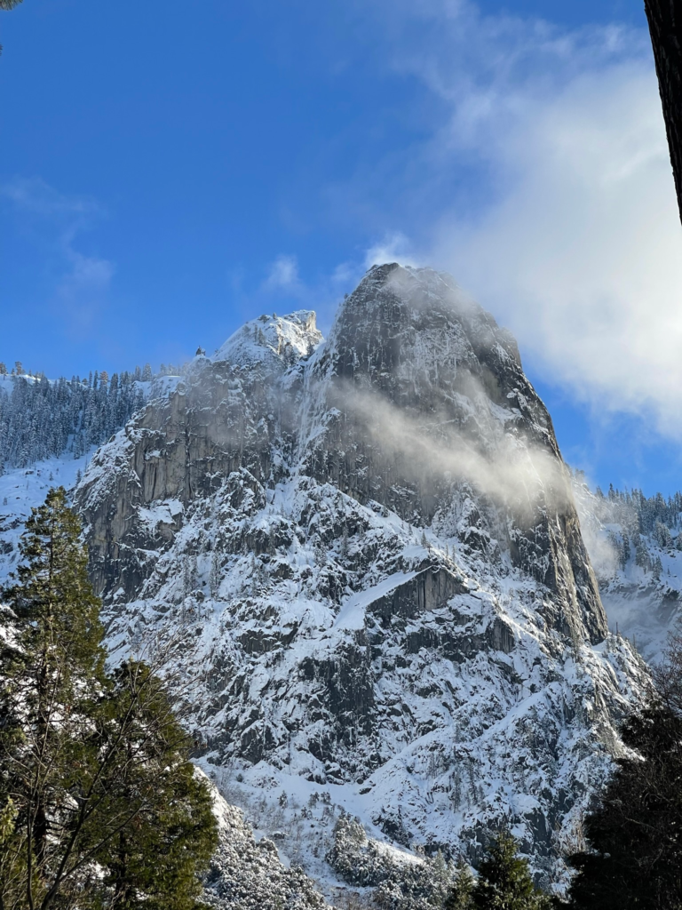 El Capitan covered in snow and surrounded by clouds at Yosemite National Park.