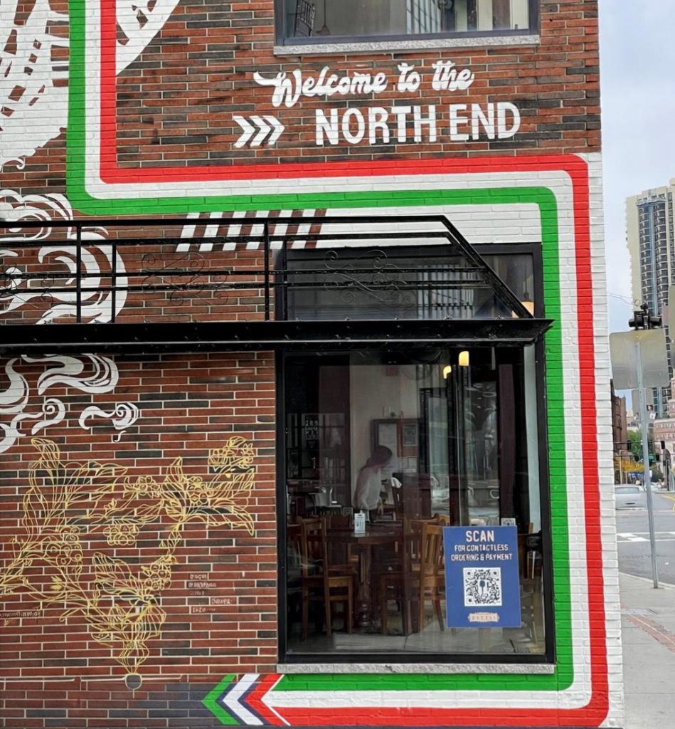 A sign saying "Welcome to the North End" on a building in the North End of Boston.